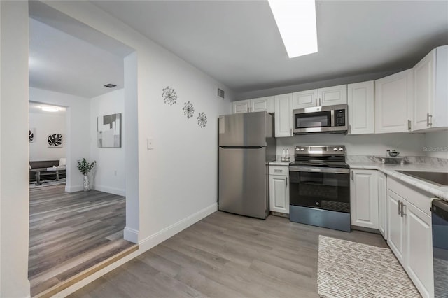 kitchen featuring stainless steel appliances, light hardwood / wood-style flooring, white cabinets, and sink