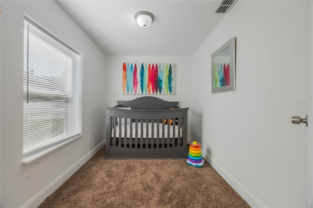 carpeted bedroom featuring a crib