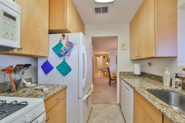 kitchen featuring light colored carpet, light brown cabinets, light stone countertops, and white appliances