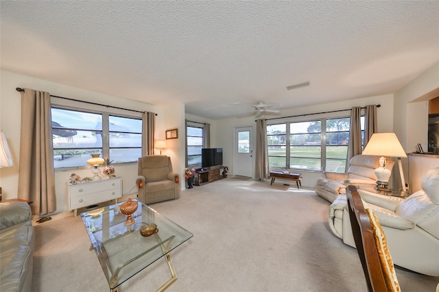 carpeted living room featuring a textured ceiling and ceiling fan