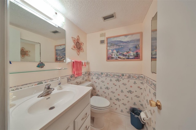 bathroom featuring tile patterned floors, vanity, toilet, and a textured ceiling