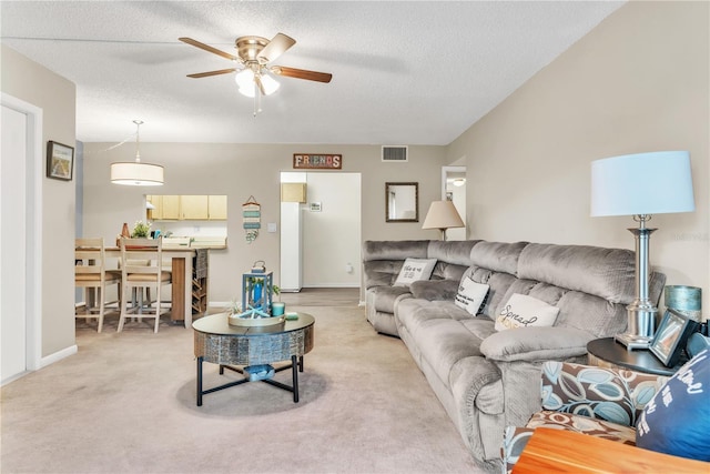 carpeted living room with ceiling fan and a textured ceiling