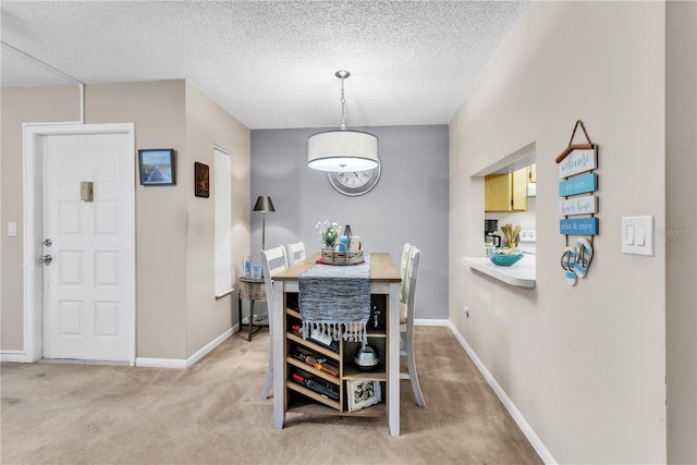 carpeted dining room with a textured ceiling