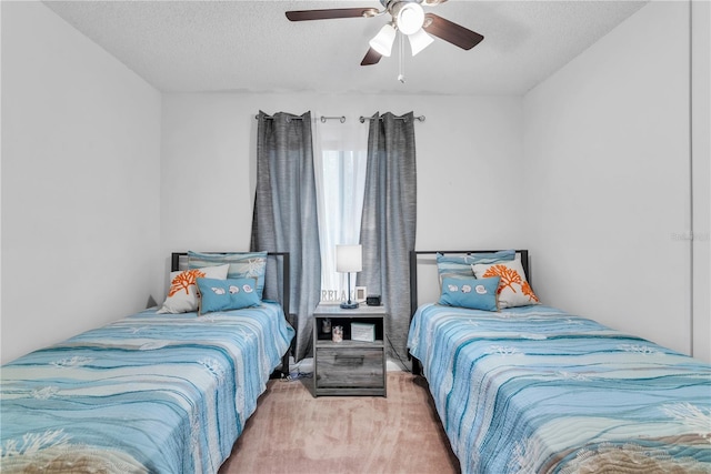 bedroom with ceiling fan, light carpet, and a textured ceiling