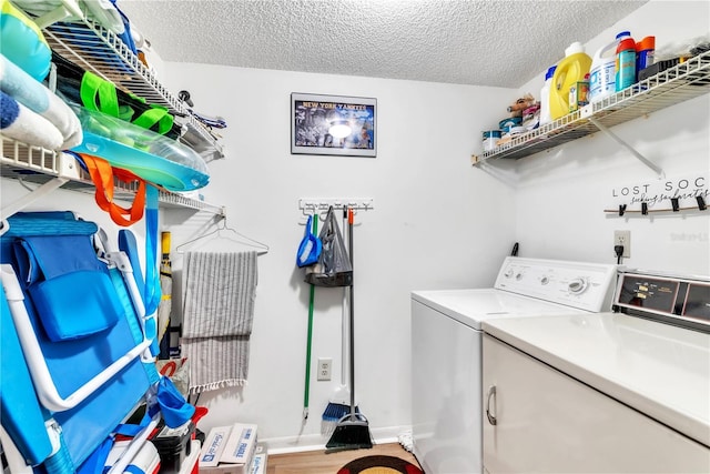 laundry room with washing machine and clothes dryer and a textured ceiling