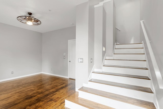 stairs with hardwood / wood-style flooring and ceiling fan