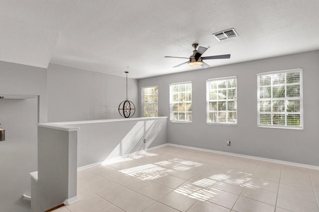 empty room with ceiling fan and light tile patterned floors