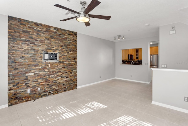 unfurnished living room featuring light tile patterned floors, rail lighting, a textured ceiling, and ceiling fan