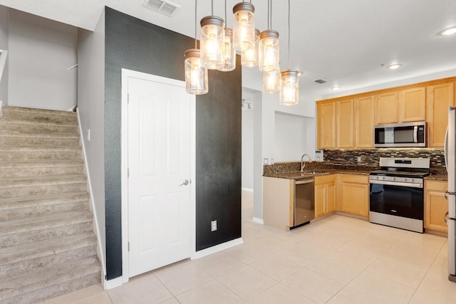 kitchen featuring sink, stainless steel appliances, pendant lighting, decorative backsplash, and light tile patterned floors