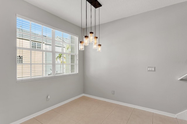 unfurnished dining area with light tile patterned floors and an inviting chandelier