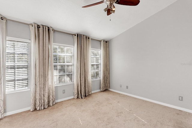 carpeted spare room with ceiling fan and lofted ceiling