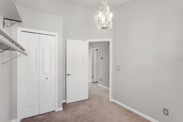 interior space with a chandelier, light carpet, and a closet