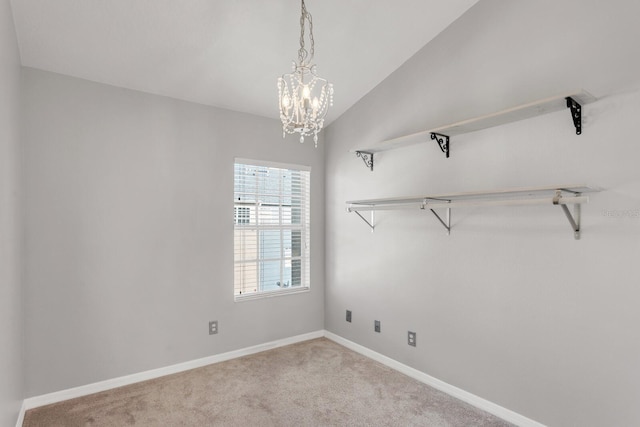 spare room with light carpet, vaulted ceiling, and an inviting chandelier