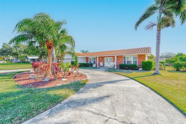 ranch-style house featuring a garage and a front lawn