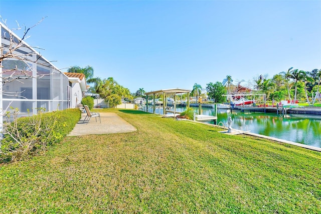 view of yard with a lanai, a dock, a water view, and a patio