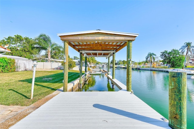 dock area with a lawn and a water view