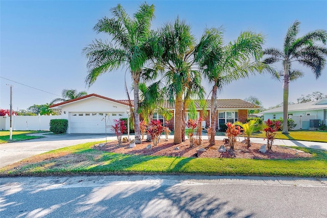 view of front of home with a front lawn, a garage, and cooling unit