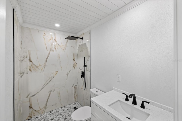 bathroom with a tile shower, toilet, vanity, wood ceiling, and ornamental molding