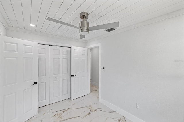 unfurnished bedroom with ceiling fan, a closet, and crown molding