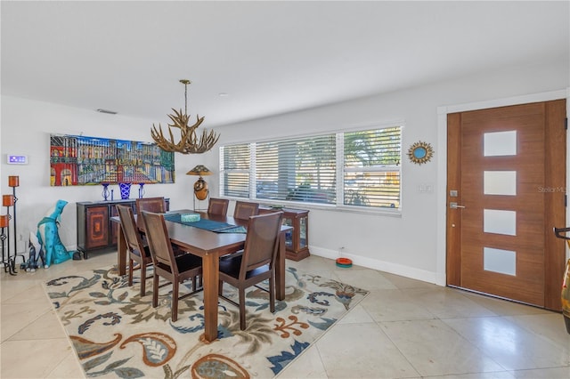 tiled dining room with a notable chandelier