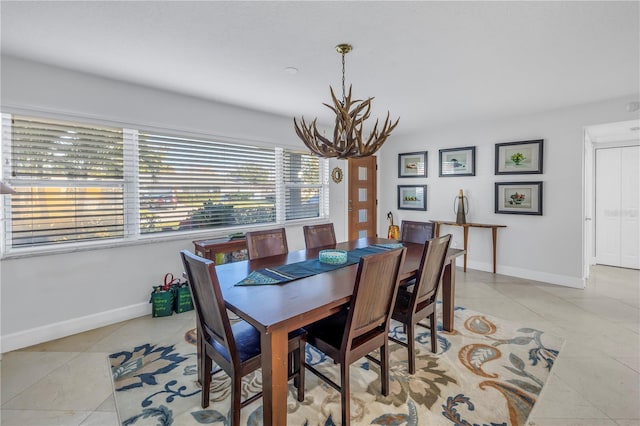 dining space featuring light tile patterned floors and an inviting chandelier