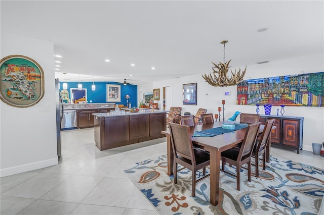 dining area with light tile patterned floors and ceiling fan with notable chandelier