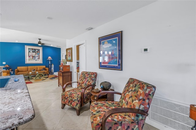 living area with ceiling fan and light tile patterned floors