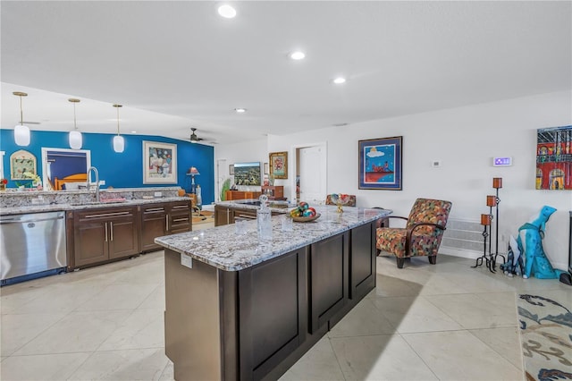 kitchen with pendant lighting, dishwasher, sink, light stone counters, and dark brown cabinetry