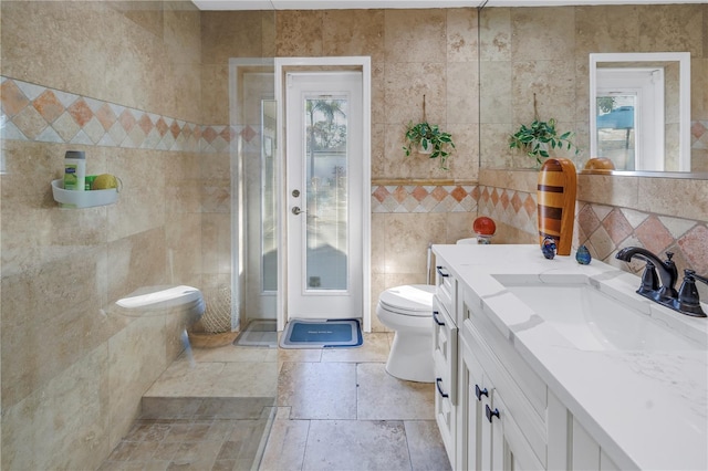 bathroom featuring vanity, tile walls, and toilet