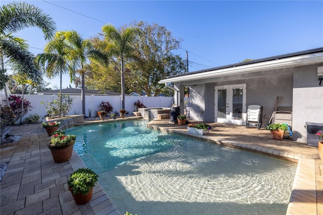 view of swimming pool featuring pool water feature, a patio, and french doors