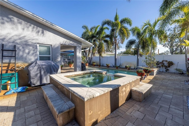 view of pool featuring an in ground hot tub, a patio, and grilling area