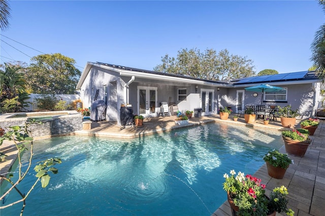 view of swimming pool with an in ground hot tub, french doors, and a patio area