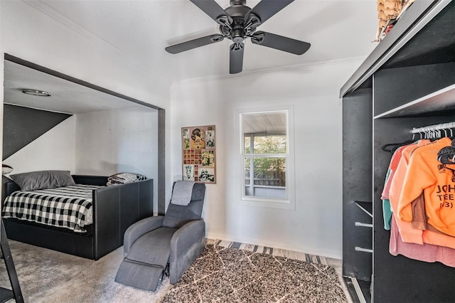 carpeted bedroom with ornamental molding, ceiling fan, and a closet