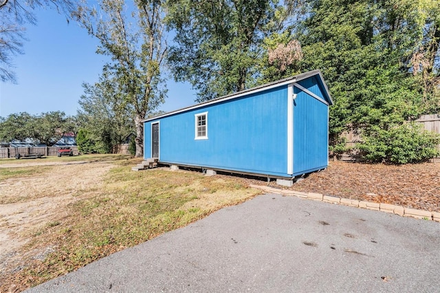 view of home's exterior featuring an outbuilding and a lawn