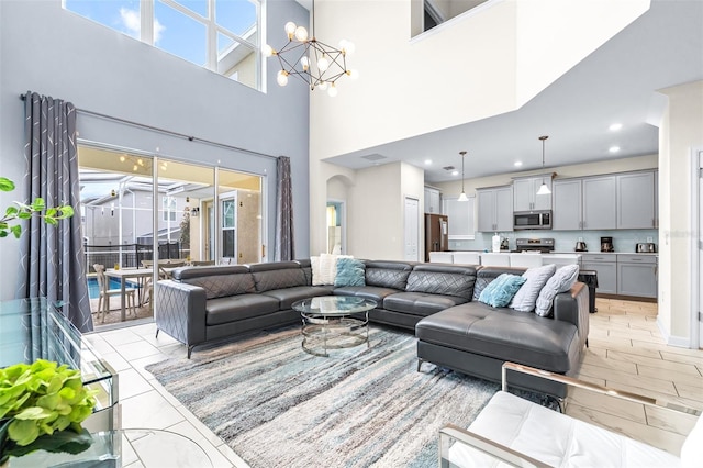 601 Drop Shot Dr, Davenport, FL 33896 - living room with a chandelier, a towering ceiling, light marble finish flooring, and recessed lighting