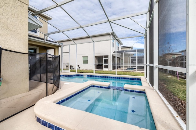 view of pool with a lanai and an in ground hot tub