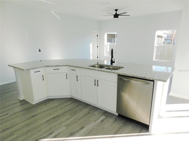 kitchen featuring white cabinetry, sink, light stone counters, stainless steel dishwasher, and an island with sink