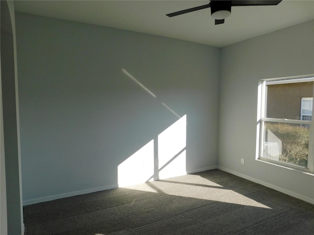 unfurnished room featuring ceiling fan and dark colored carpet