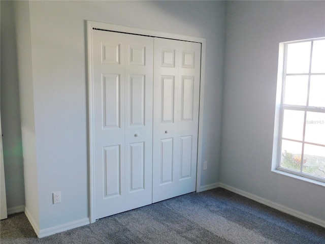 unfurnished bedroom with carpet and a closet