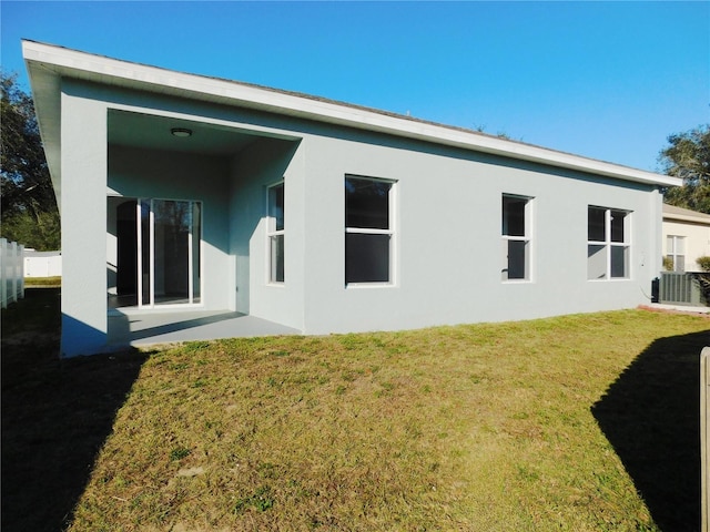 back of house with central AC and a yard