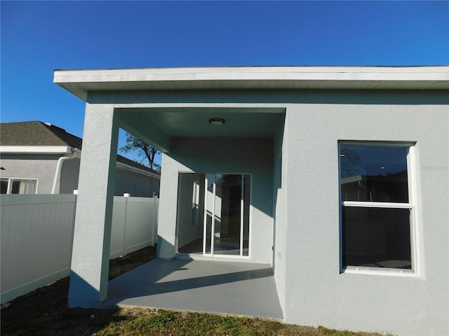 view of exterior entry with a patio