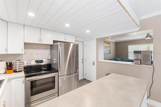 kitchen featuring ornamental molding, white cabinetry, stainless steel appliances, and tasteful backsplash