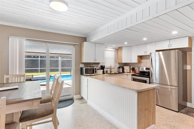 kitchen featuring tasteful backsplash, white cabinetry, sink, and appliances with stainless steel finishes