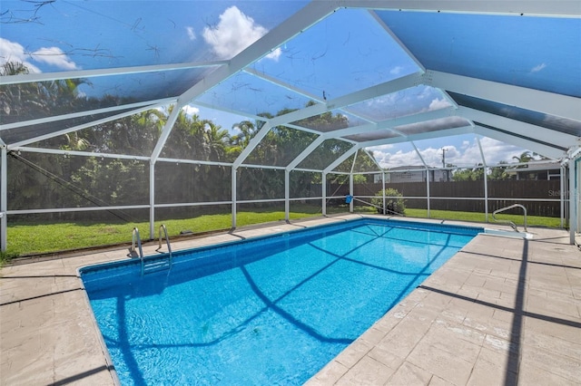 view of swimming pool with a patio area, a lanai, and a lawn