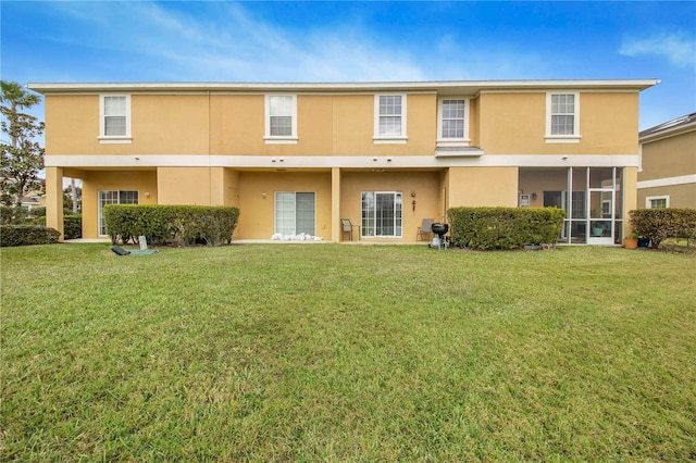 rear view of property featuring a lawn