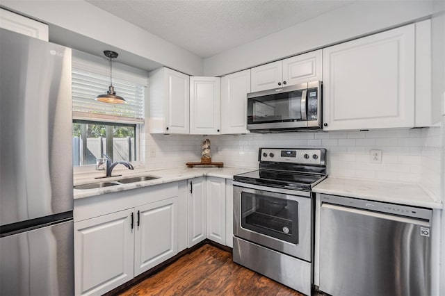 kitchen with white cabinetry, sink, stainless steel appliances, dark hardwood / wood-style floors, and a textured ceiling