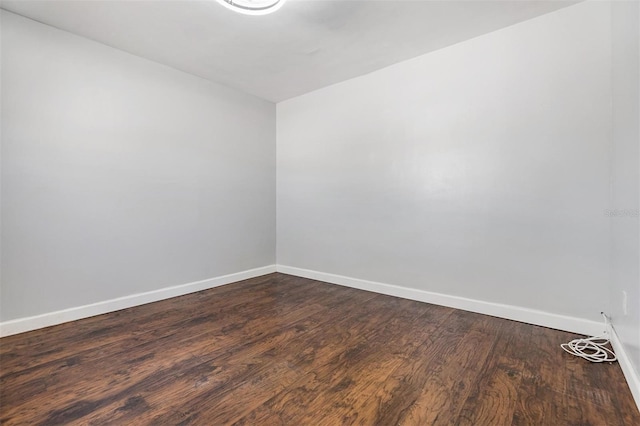 unfurnished room with dark wood-type flooring