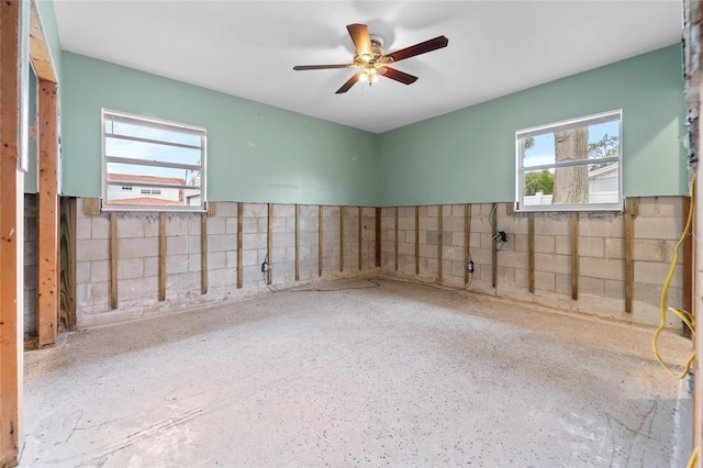 empty room featuring ceiling fan and a wealth of natural light