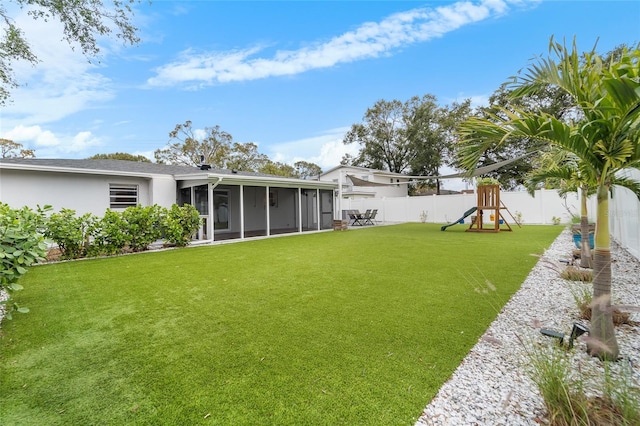 view of yard featuring a playground and a sunroom