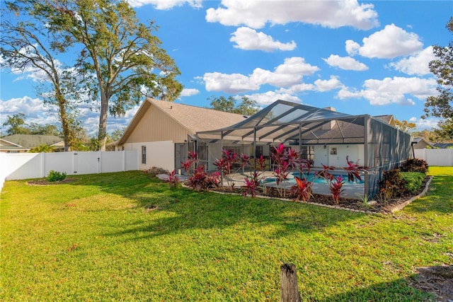 back of house with a yard, glass enclosure, and a patio area